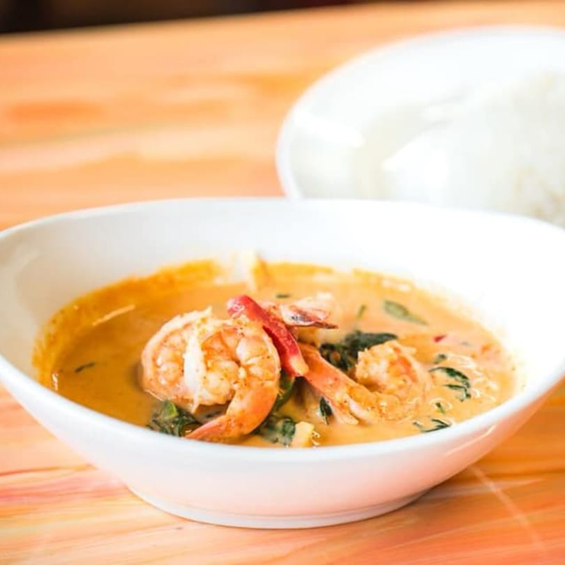 Nisa Thai Asian Cuisine's red curry with shrimp and basil, served with white rice.